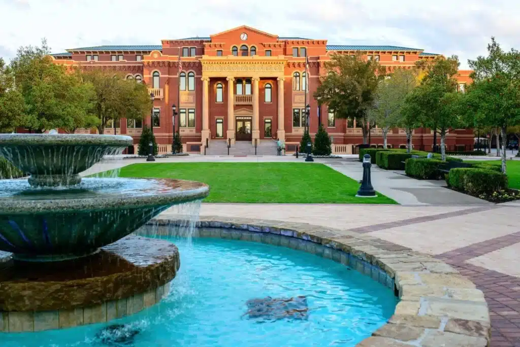 Foreground fountain and red-brick campus building