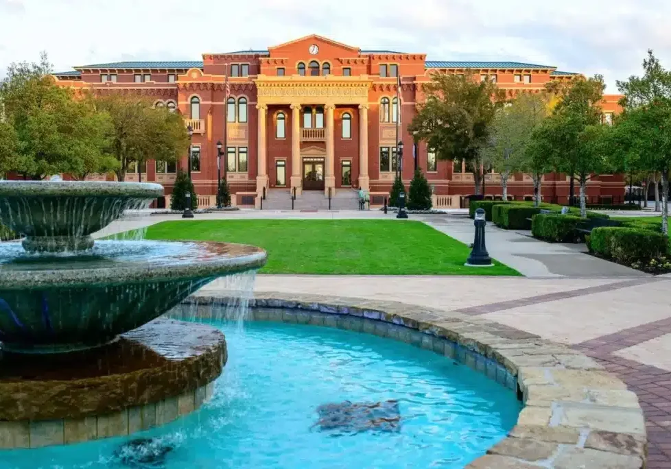 Foreground fountain and red-brick campus building